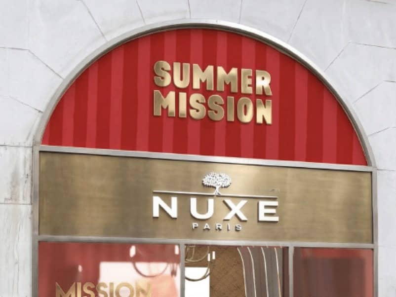 Scénographie estivale du pop-up Nuxe, bois flotté, osier et sols bleu piscine