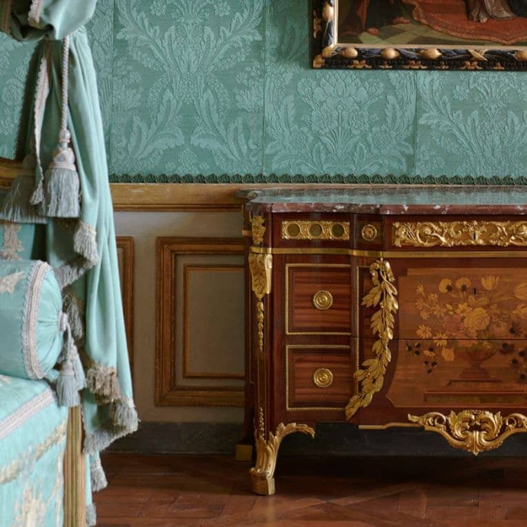 Commode marquetée à bronzes dorés devant une tenture de soie vert d'eau dans les appartements de l'Hôtel de la Marine