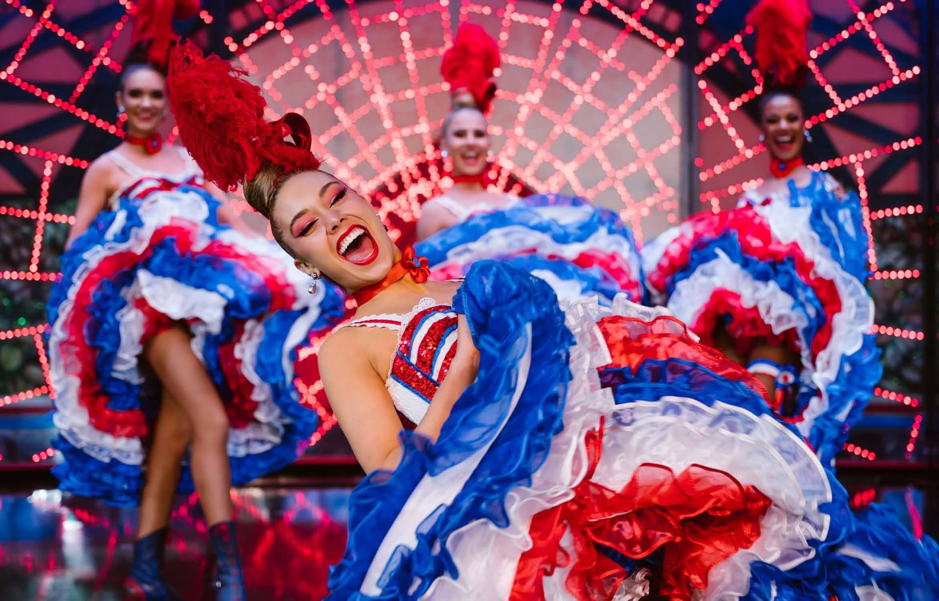 Danseuses de French cancan du Moulin Rouge en robes à volants bleu, blanc et rouge, sur scène