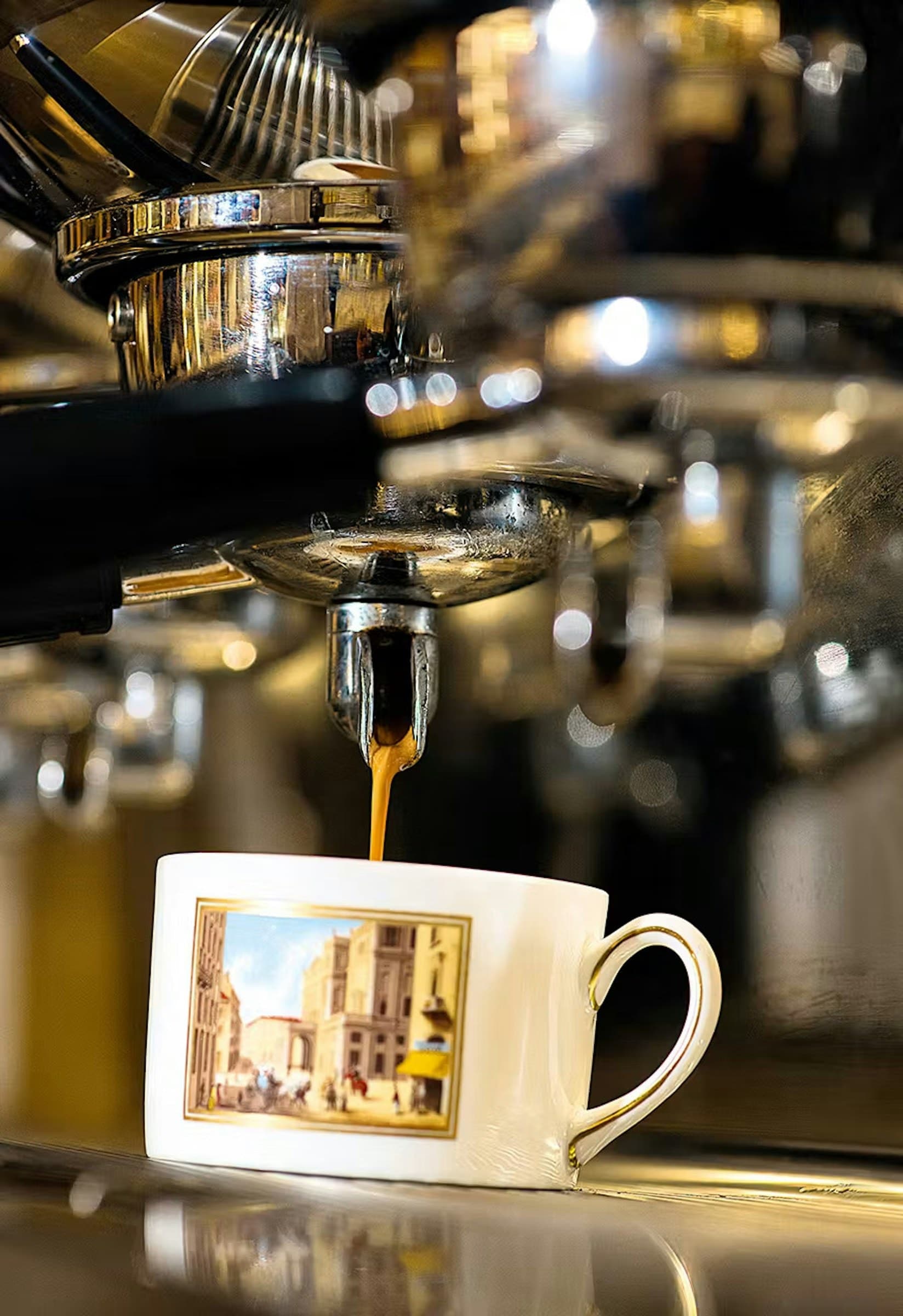 Espresso qui coule d'une machine chromée dans une tasse Cova illustrée d'une rue de Milan