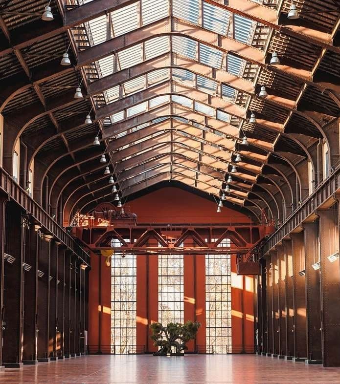 La nef de la Cité du Cinéma à Saint-Denis, verrière et poutres d'acier baignées de lumière rasante