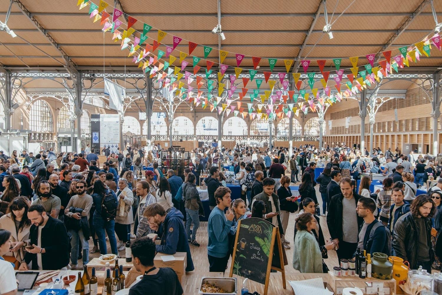 La halle du Carreau du Temple pavoisée de fanions et remplie de tablées pendant Food Temple