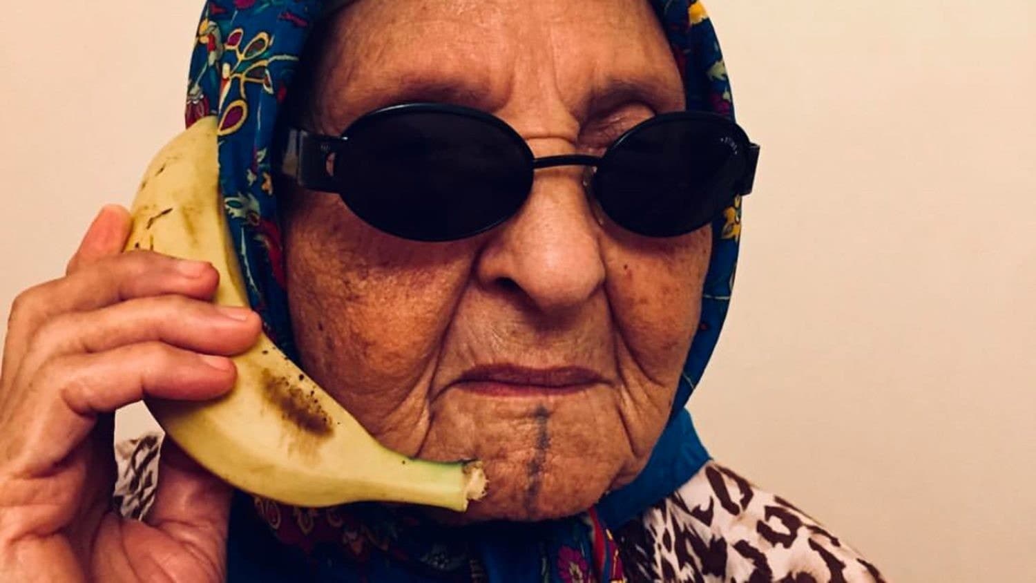 Portrait d'une Marocaine en foulard tenant une banane comme un téléphone, visuel de Food Temple Maroc