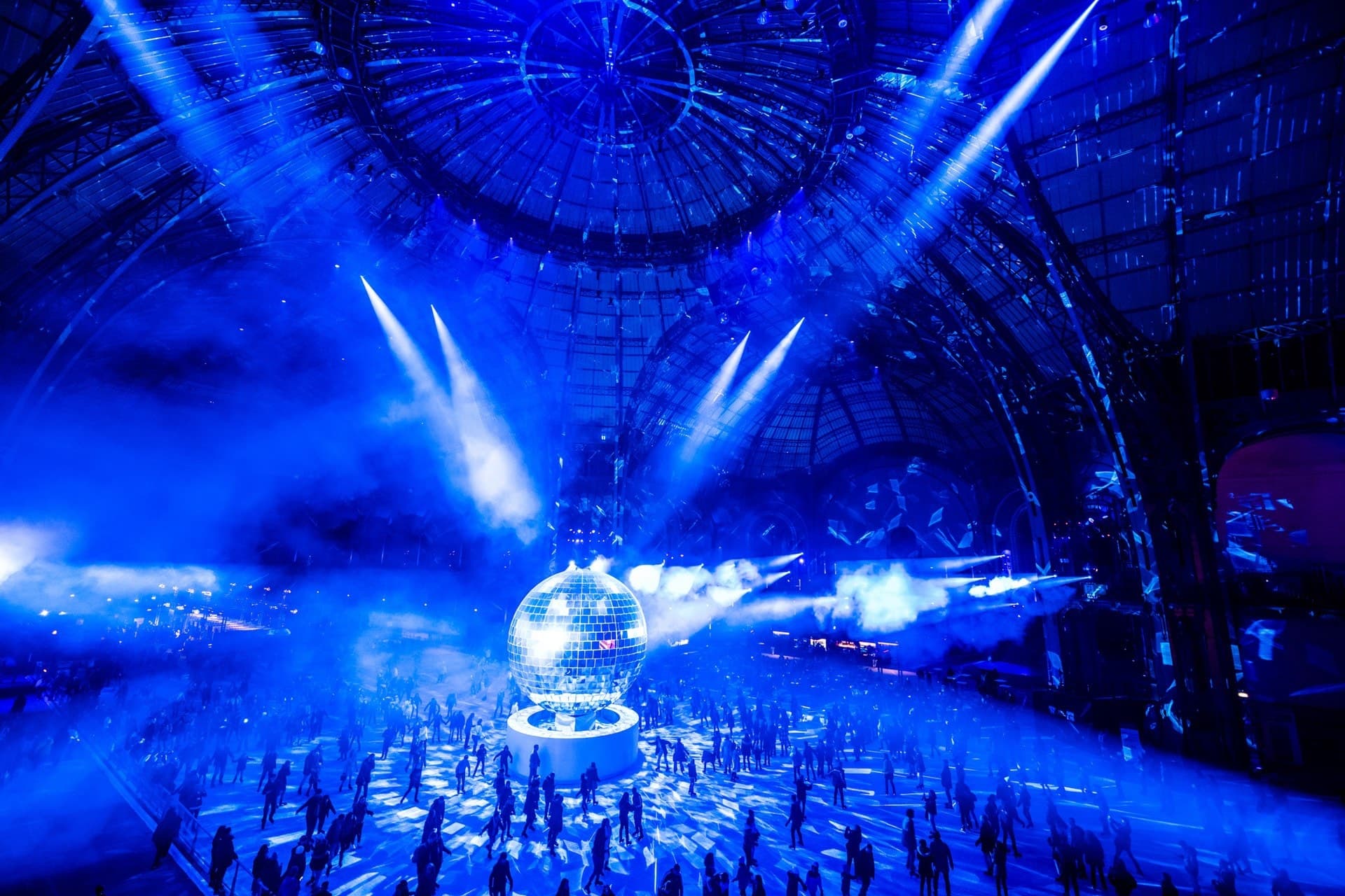 La nef du Grand Palais plongée dans une lumière bleue pendant une nocturne de la patinoire