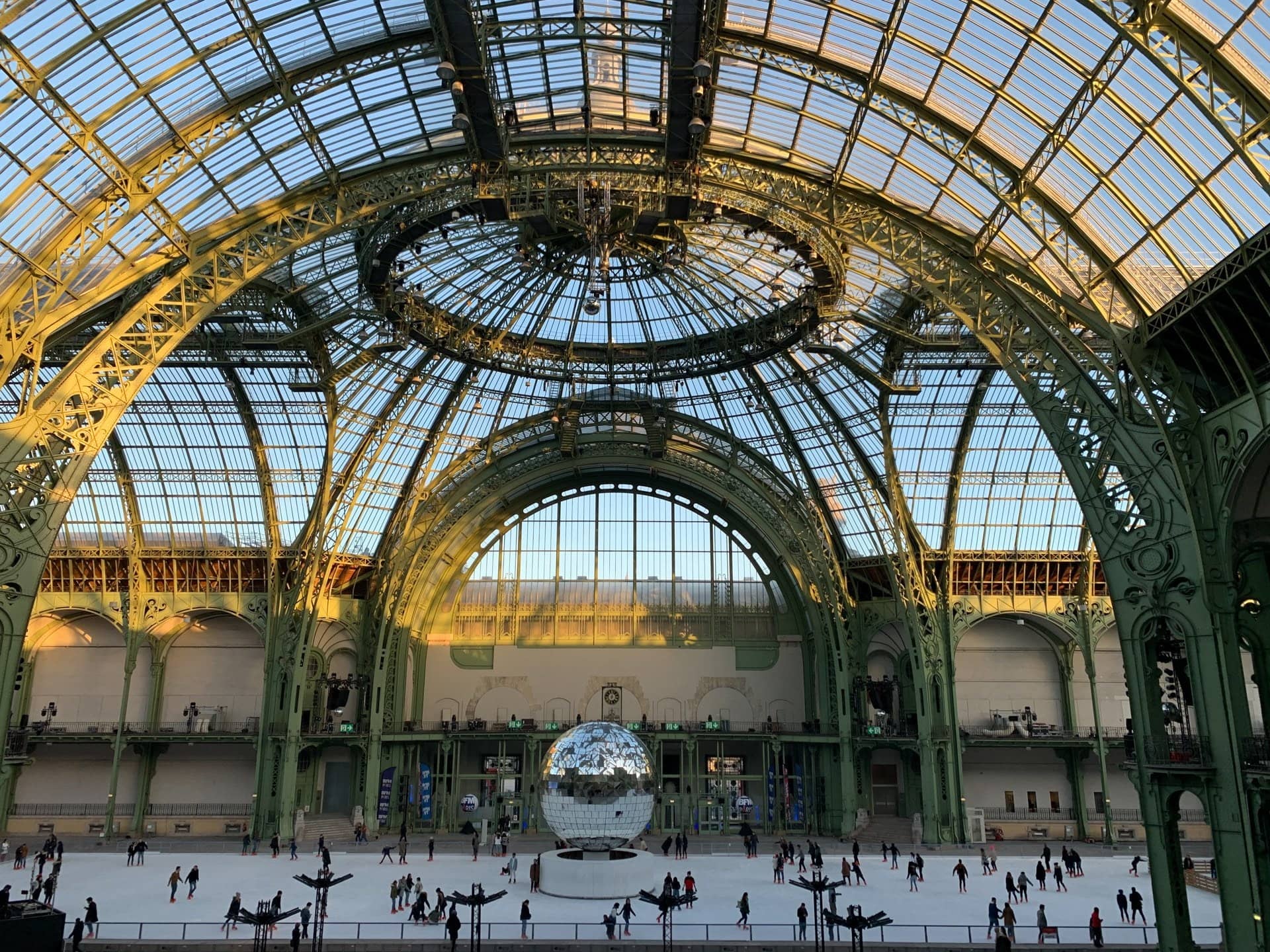 La patinoire du Grand Palais de jour, sous la verrière, avec une boule à facettes géante au centre