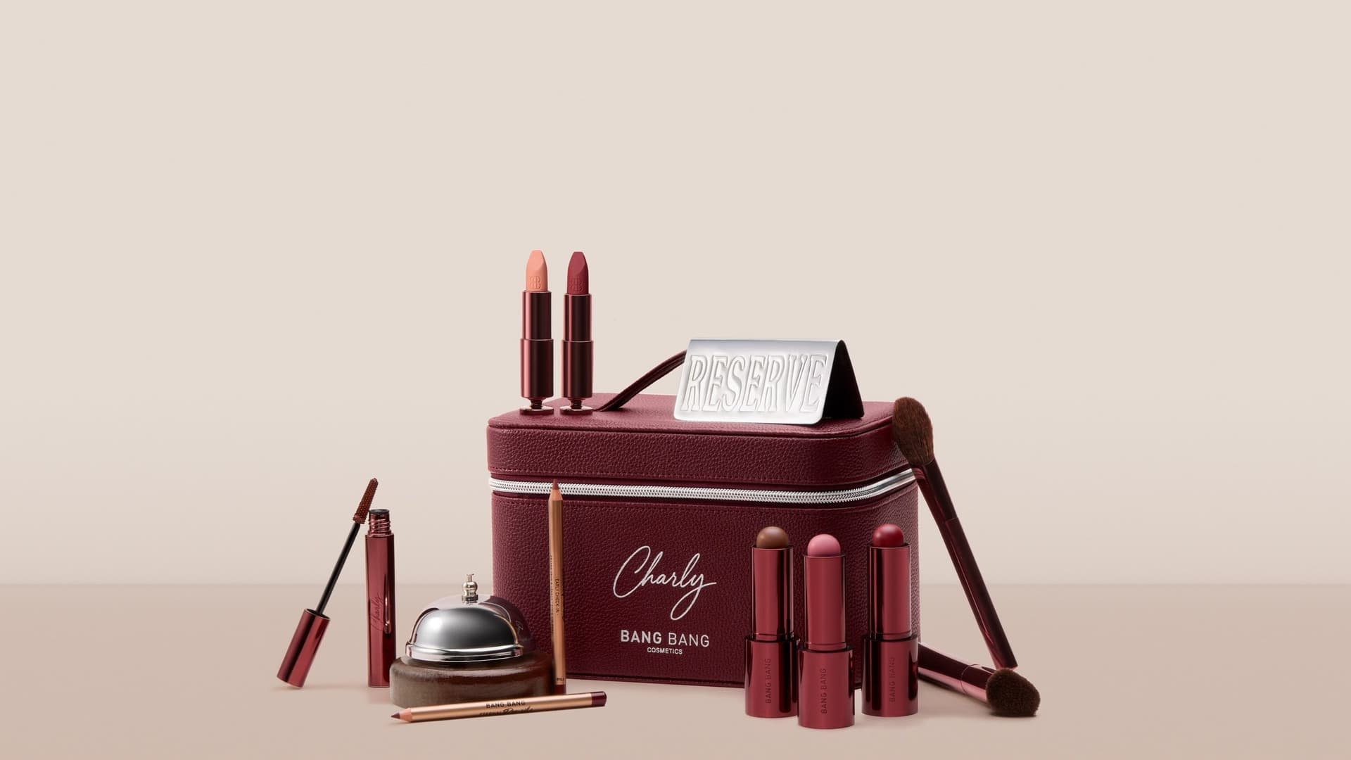 Burgundy Hôtel Charly vanity case by BANG BANG with lipsticks, pencils, brushes and a hotel bell
