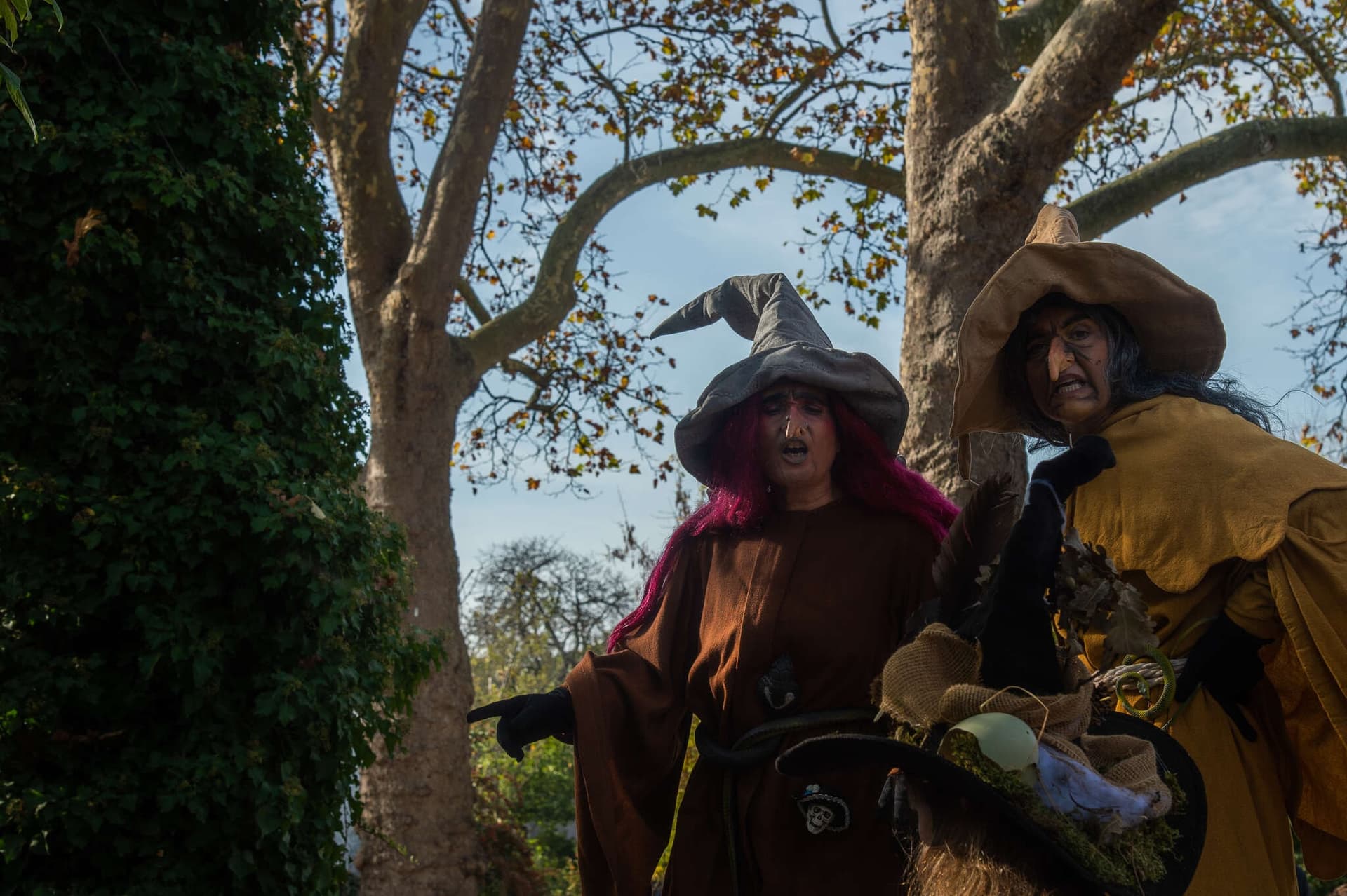 Two witches in pointed hats under the trees of the Paris zoo for the Journée Frissons Halloween day