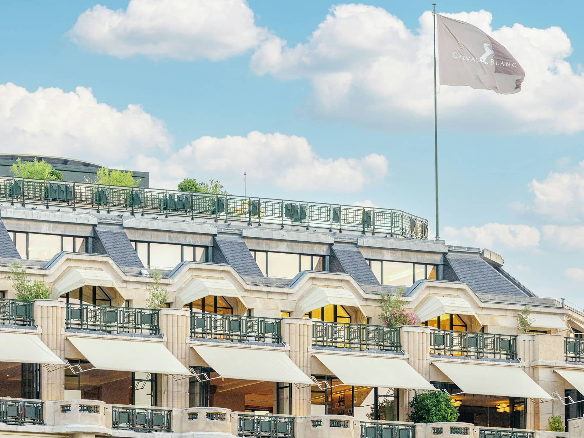 Façade et terrasses du Cheval Blanc Paris quai du Louvre sous un ciel bleu, drapeau au sommet