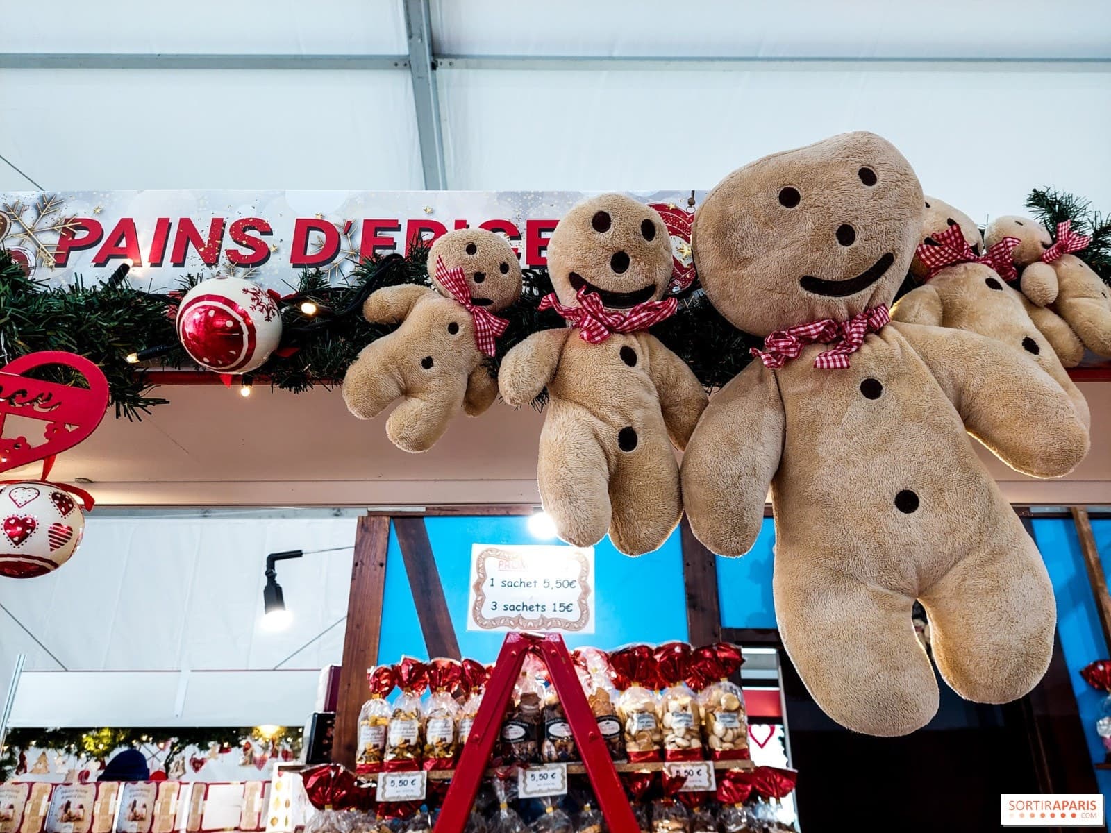 Plush gingerbread men hanging above a stall at the Alsatian Christmas market at Gare de l'Est, 2022 edition