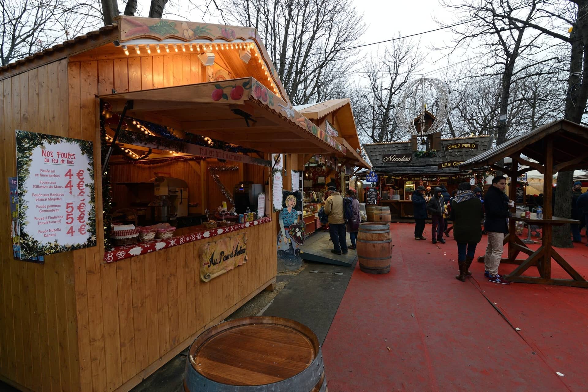 Chalet en bois illuminé et visiteurs au marché de Noël des Champs-Élysées, édition 2014