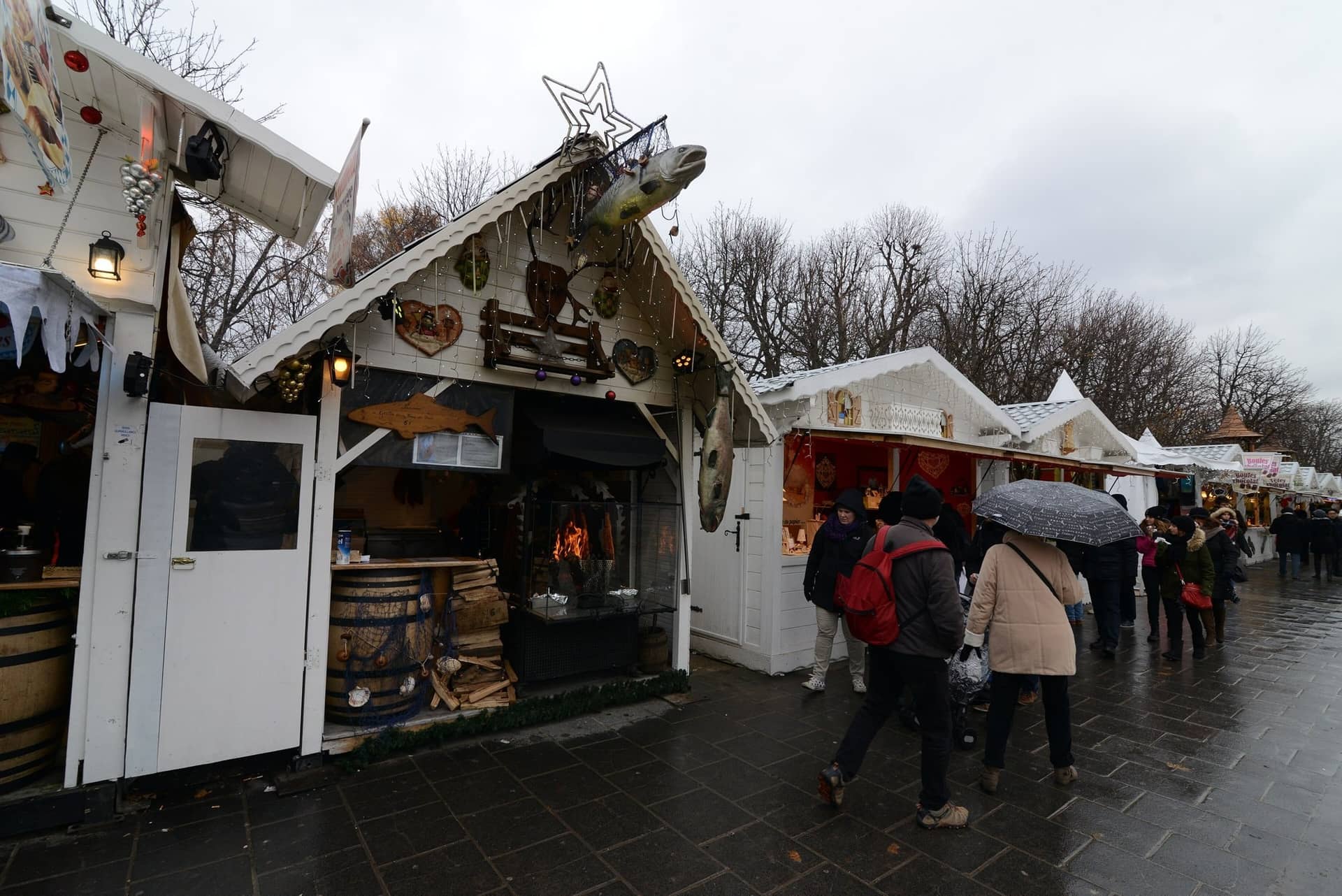 Allée de chalets blancs décorés sur le bas des Champs-Élysées un soir de pluie, édition 2014
