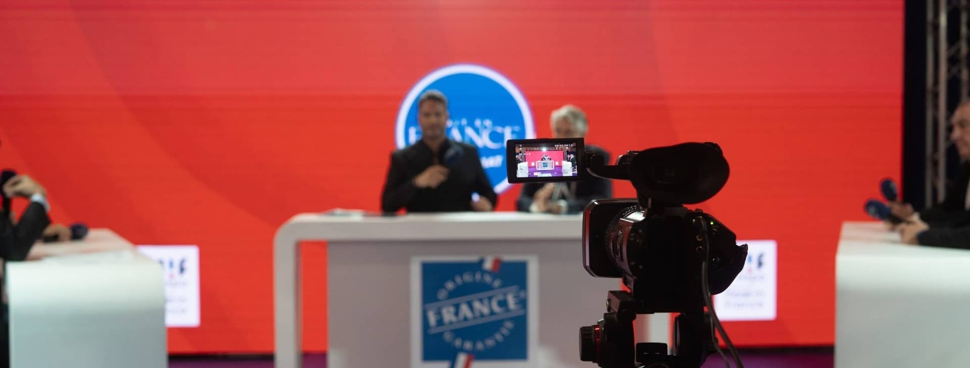 Le plateau télé Origine France Garantie du salon MIF Expo, fond rouge, un animateur face à la caméra