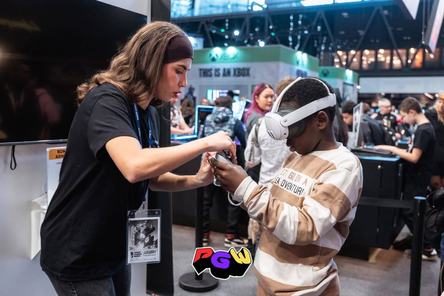 Une animatrice ajuste un casque de réalité virtuelle sur un enfant à la Paris Games Week