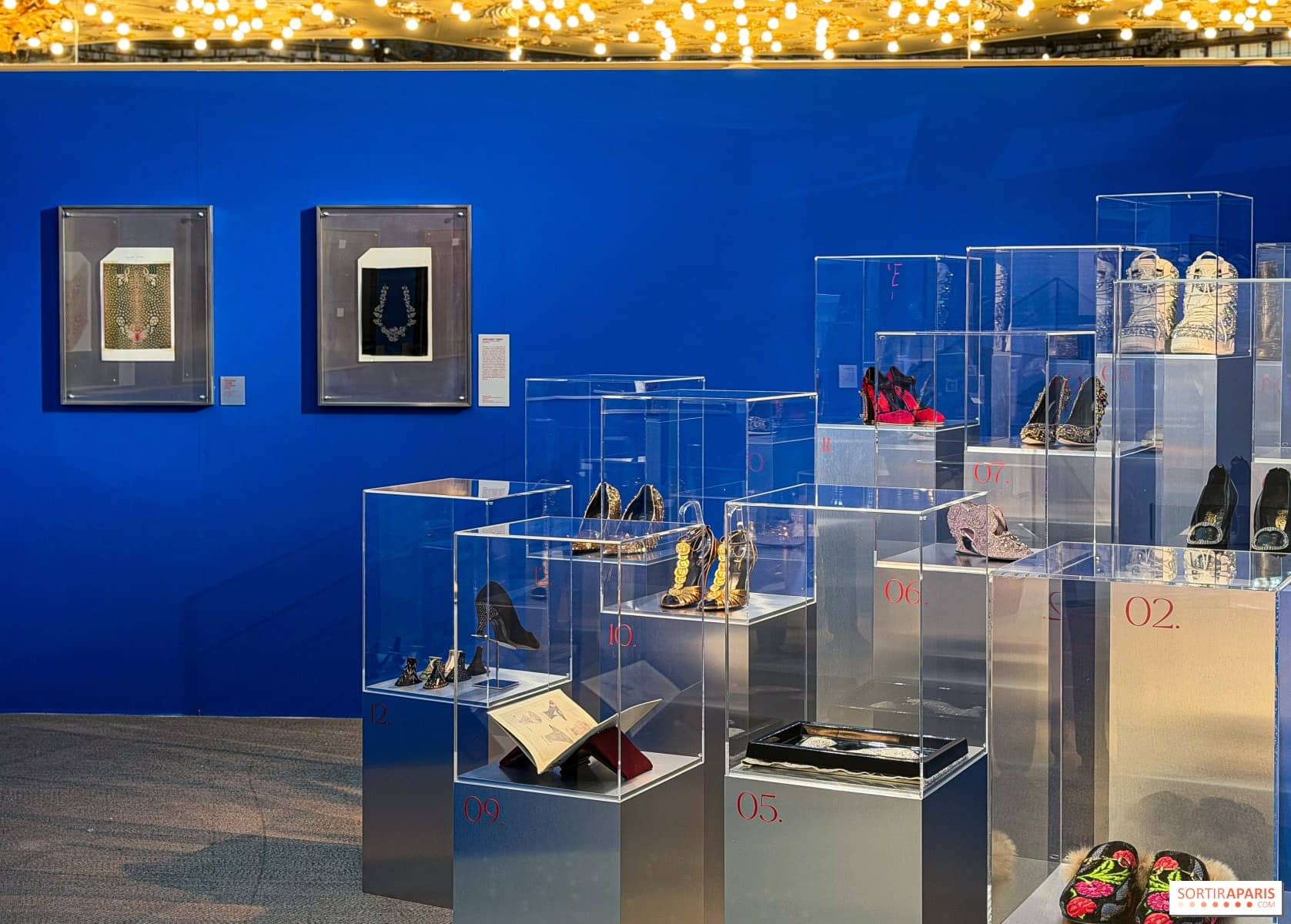 Salle bleue de l'exposition Pas à Pas avec des souliers sous cloches de plexiglas au Printemps Haussmann
