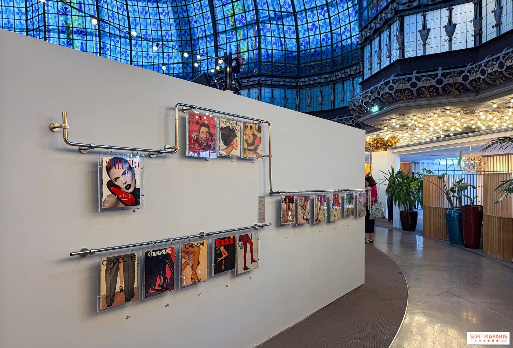 Cimaise de l'exposition Pas à Pas installée sous la coupole en vitrail du Printemps Haussmann