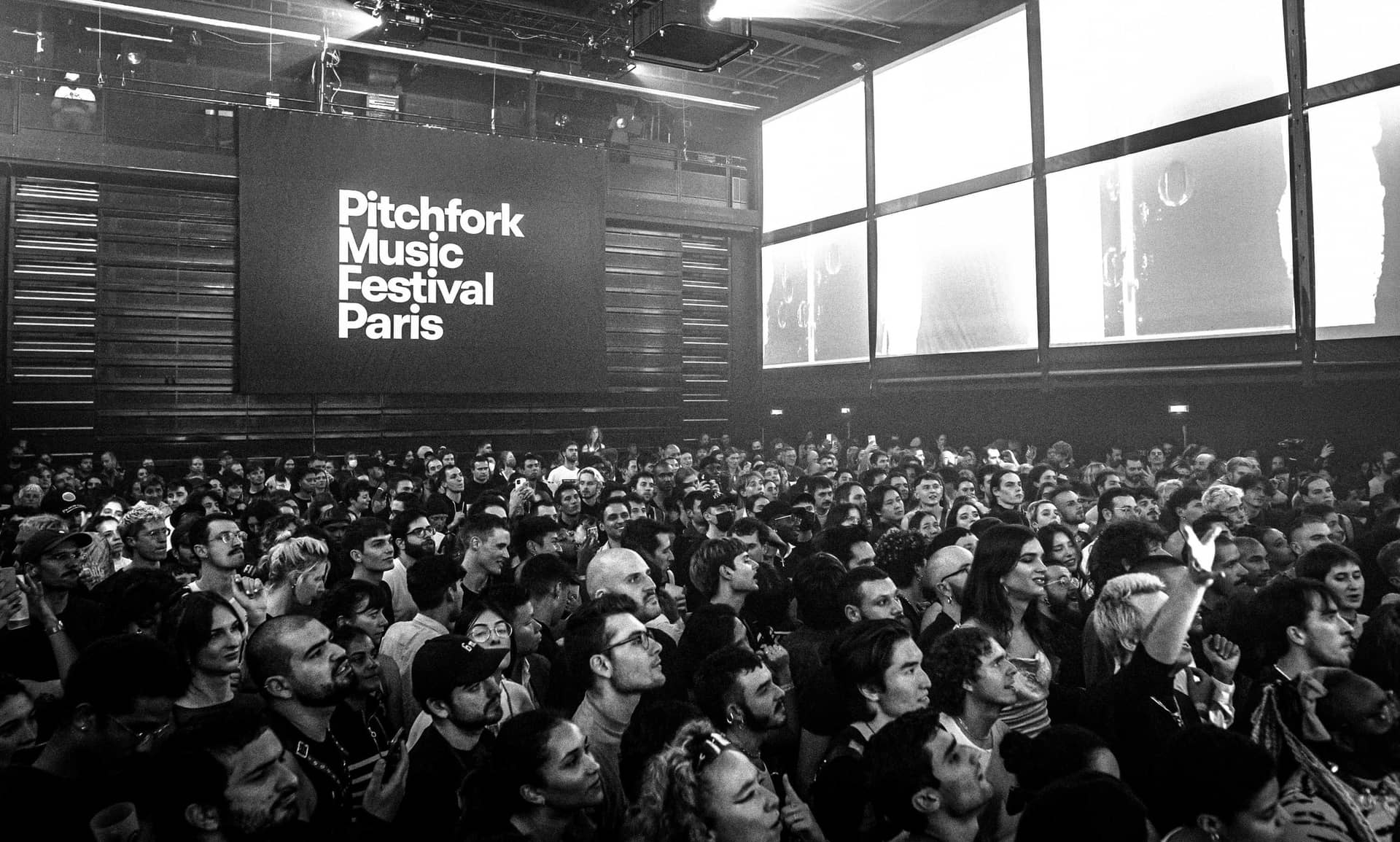 Salle comble devant l'écran Pitchfork Music Festival Paris, photo noir et blanc d'une édition passée