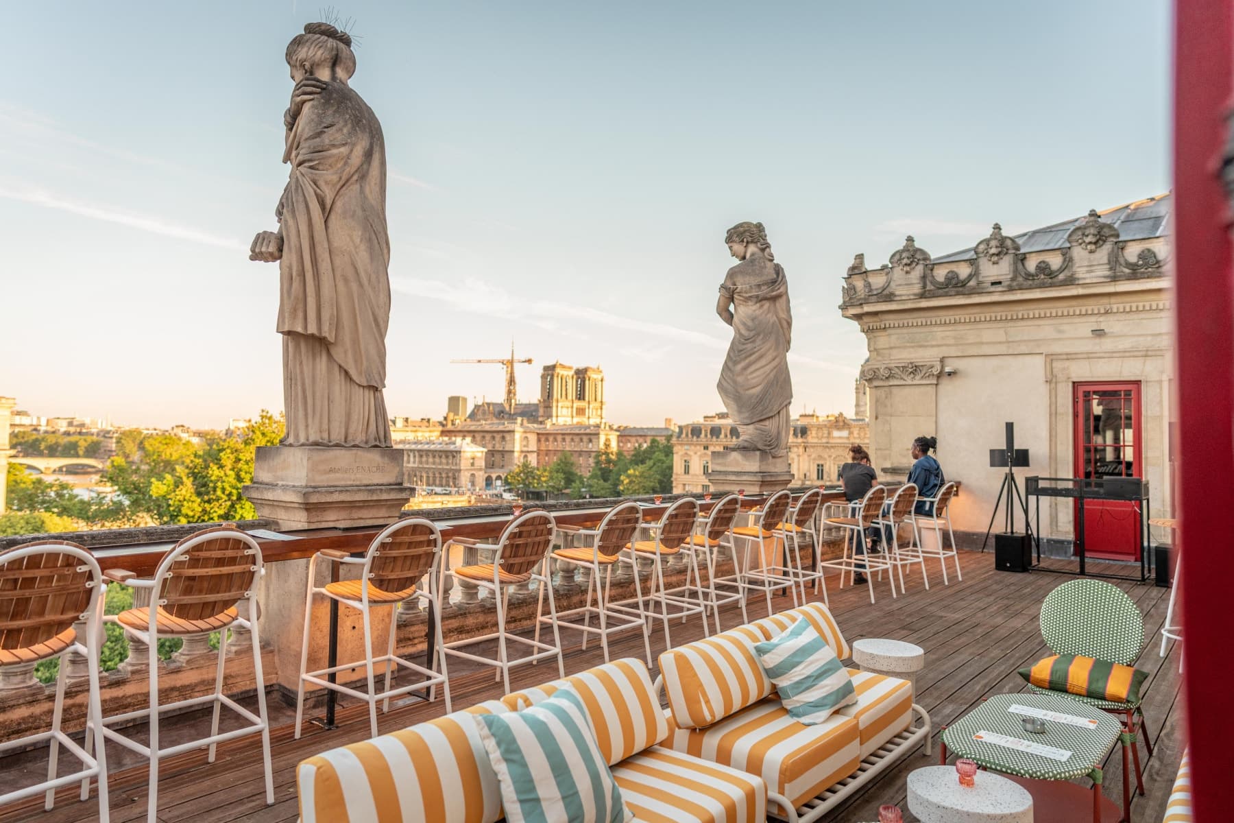 Terrasse rooftop du Théâtre du Châtelet avec cariatides de pierre et vue sur Notre-Dame au coucher du soleil