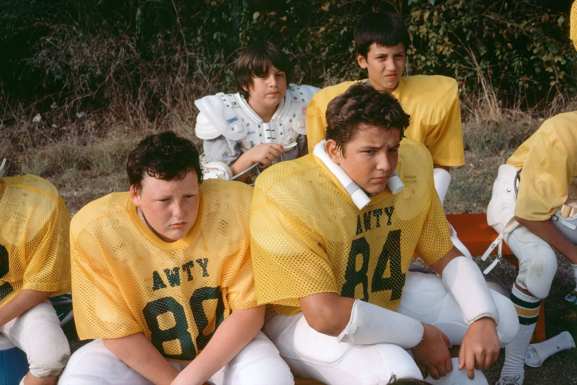 Diapositive Kodachrome de 1981 : jeunes joueurs de football américain en maillot jaune assis dans l'herbe