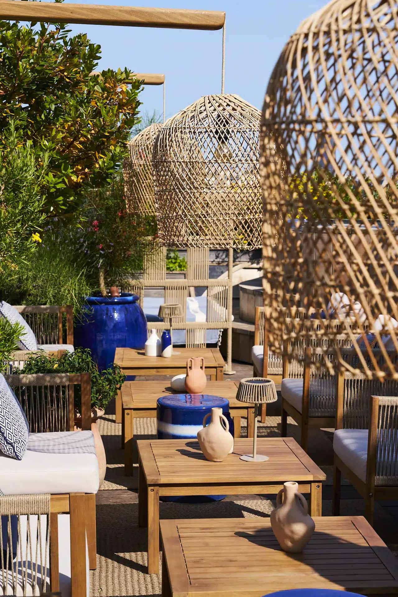Terrasse du rooftop du Brach avec transats en teck, lampions en osier et oliviers en pot, ambiance méditerranéenne